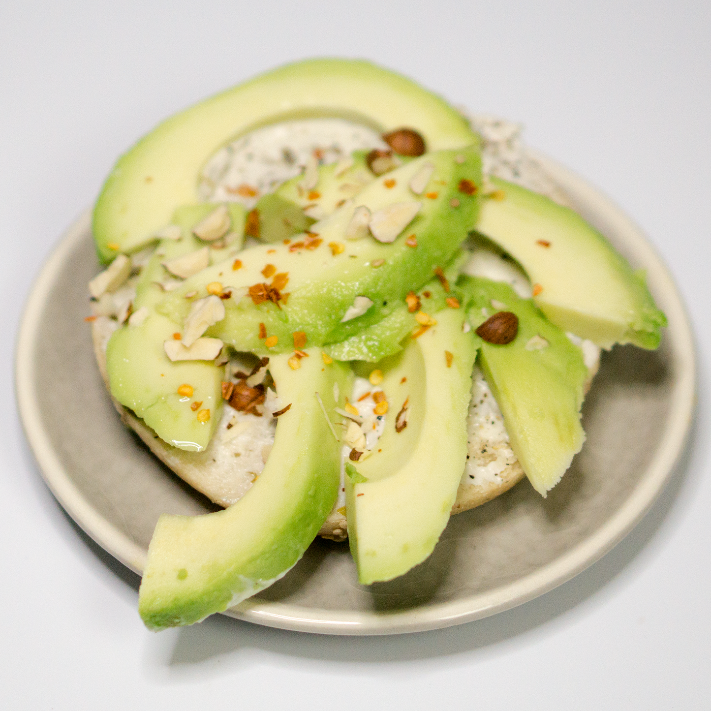 Avocado-Bagel mit veganer Cashewcreme und Haselnüssen